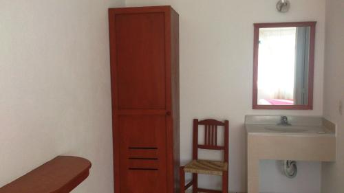 a bedroom with a tall wooden cabinet next to a sink at Hotel Maricarmen in Manzanillo
