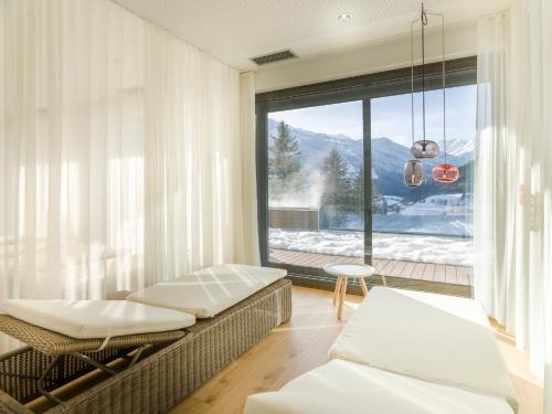salon z kanapą i dużym oknem w obiekcie Hotel Goldried w mieście Matrei in Osttirol