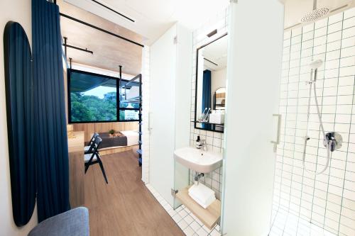 a bathroom with a sink and a mirror and a shower at lyf Funan Singapore in Singapore