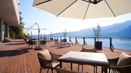 un patio con tavoli, sedie e vista sull'acqua di Aki Grand Hotel & Spa a Miyajima