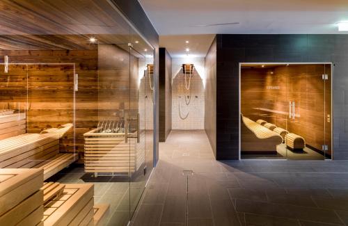 Łazienka z drewnianymi ścianami i kabiną prysznicową w obiekcie Hotel Goldried w mieście Matrei in Osttirol