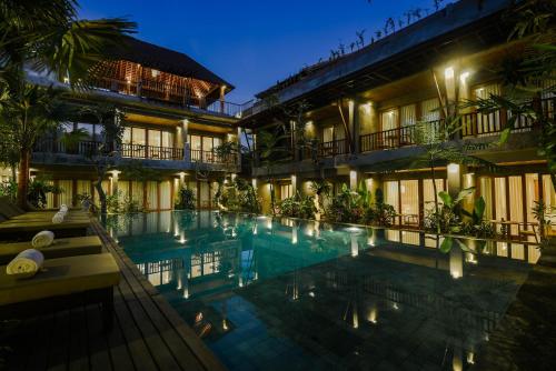 a hotel with a swimming pool at night at Purana Suite Ubud in Ubud