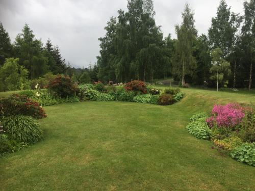 a garden with colorful flowers in the grass at The Garden Room at Te Anau Country Accommodation in Te Anau
