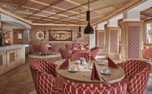 jadalnia ze stołem i czerwonymi krzesłami w obiekcie Hotel Goldener Greif w mieście Kitzbühel