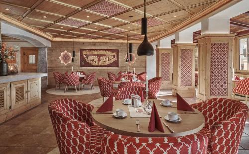 a dining room with a table and red chairs at Hotel Goldener Greif in Kitzbühel