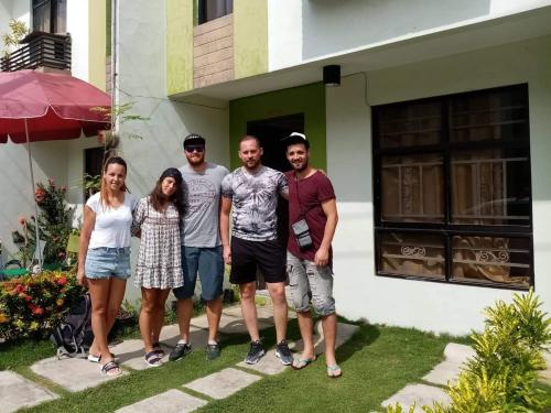 a group of people standing in front of a house at Haus of Emerald by JeYo in Mactan