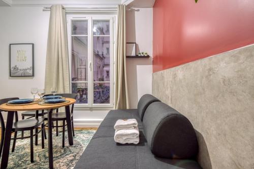 un salon avec un canapé et une table dans l'établissement Basilique du Sacré Coeur - Beautiful 2P apartment, à Paris