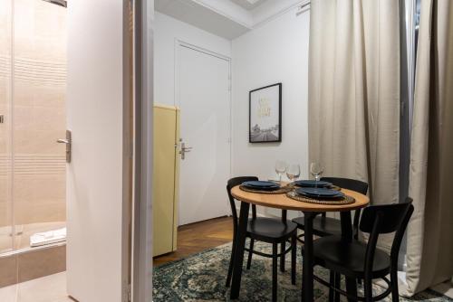 une salle à manger avec une table et des chaises noires dans l'établissement Basilique du Sacré Coeur - Beautiful 2P apartment, à Paris