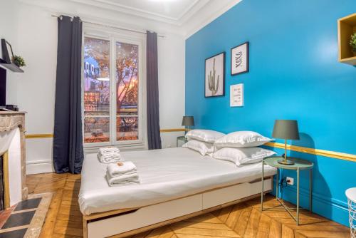 une chambre bleue avec un lit et une fenêtre dans l'établissement Basilique du Sacré Coeur - Beautiful 2P apartment, à Paris