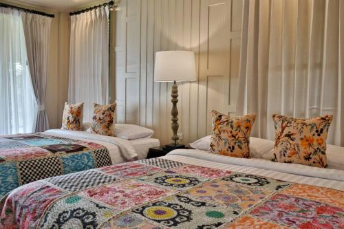 a hotel room with two beds and a lamp at Shantaa Resort, Kohkood in Ko Kood
