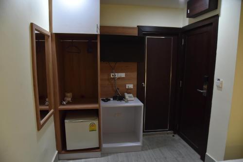 a small kitchen with a refrigerator in a room at Rose Nana Hotel in Bangkok