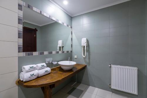 a bathroom with a sink and a mirror and towels at Drevny Grad Park-hotel in Lviv