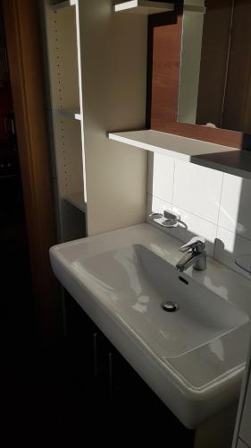 a white sink in a bathroom with a mirror at Easy living in Bad Hofgastein