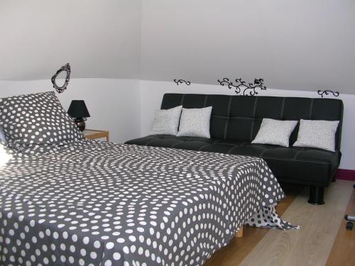 a bedroom with a black bed and a couch at CHEZ PIMLINE in Saint-Aubin-sur-Quillebeuf
