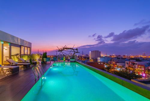 a swimming pool on the roof of a building at night at Prana Boutique Hotel and Apartments in Da Nang