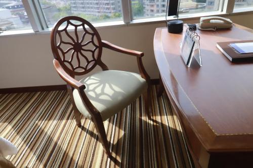 a wooden desk with a chair in front of a table at Jin Jiang Tower in Shanghai
