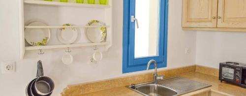 a kitchen with a sink and a blue window at Finiki Villas in Foinikion