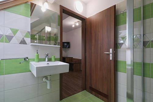 W łazience znajduje się umywalka i lustro. w obiekcie Restaurant Penzion City w mieście Jirkov