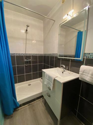 une salle de bain avec un lavabo, un miroir et une baignoire dans l'établissement Appart'Hotel Festival Sud Suites - Avignon TGV, à Avignon