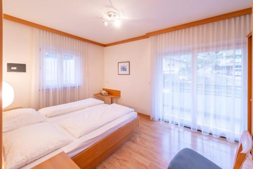 a bedroom with a large bed and a large window at Angerhof in Caldaro