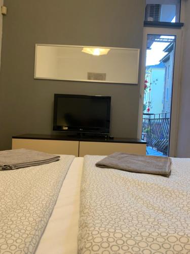 two beds in a room with a flat screen tv at Lovely place in Sofia