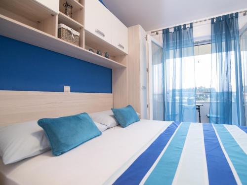 een slaapkamer met een groot bed met blauwe en witte kussens bij Apartments Marli in Split