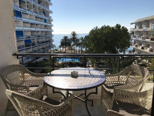 a table on a balcony with a view of the ocean at Skol Apartments Marbella in Marbella