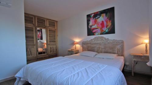 a bedroom with a bed and a painting on the wall at Les Geais - Marevalande in Sainte-Maxime