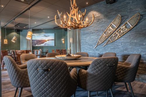 a dining room with a table and chairs and a chandelier at Hotell Storforsen in Bredsel