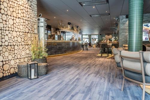 a restaurant with a wooden floor and a bar at Hotell Storforsen in Bredsel