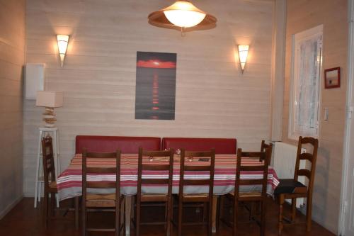 a dining room with a table and red chairs at Chez Augustin in Lacanau-Océan