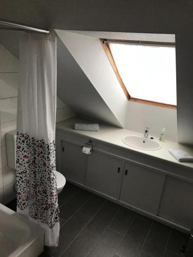 La salle de bains est pourvue d'un lavabo et d'un rideau de douche. dans l'établissement Ferienwohnung Nesthäkchen, à Hanerau-Hademarschen
