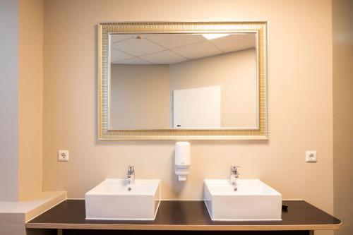 a bathroom with two sinks and a mirror at BoxHotel Hannover in Hannover