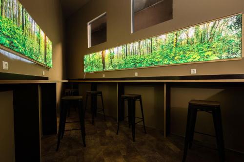 a row of bar stools in a room with windows at BoxHotel Hannover in Hannover