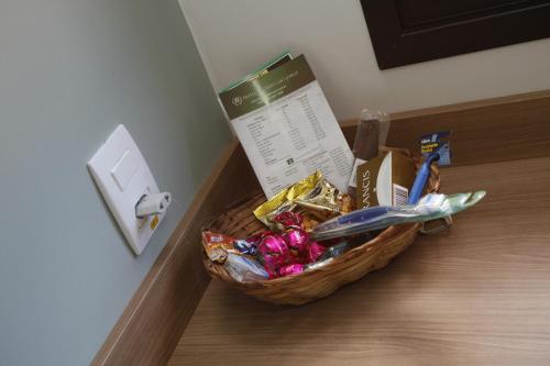 a basket of food on the floor next to a lightswitch at Hotel Recreio São Jorge in Jaboticabal