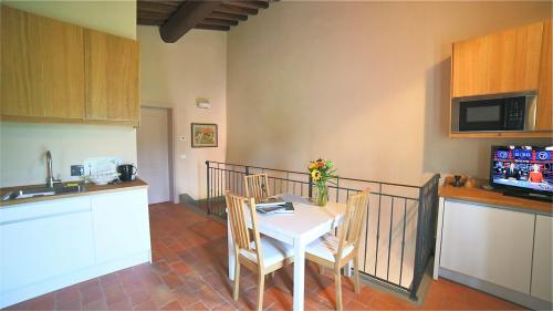 une cuisine avec une table blanche et des chaises dans l'établissement podere Sanlorenzo, à Carmignano