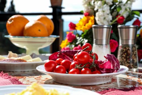 a table with plates of food and fruits and flowers at Hotel Villa Sonia in Taormina