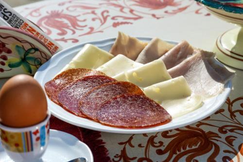 a plate of food with meat and cheese on a table at Hotel Villa Sonia in Taormina