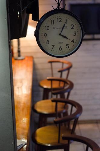 a clock is hanging above some tables and chairs at Hôtel Restaurant La Ribaudière in Antananarivo