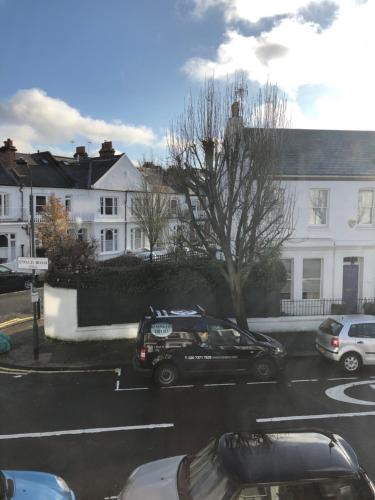 a black car parked in a parking lot with buildings at Victoria Villas in London