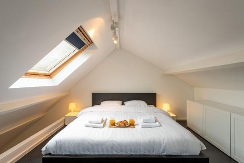 a bedroom with a bed with two oranges on it at Flagey Penthouse Duplex in Brussels