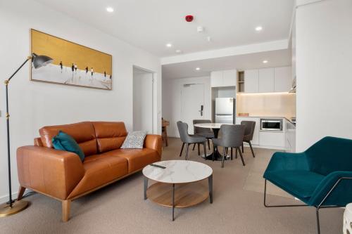 a living room with a couch and a table at The Sebel Melbourne Moonee Ponds in Melbourne