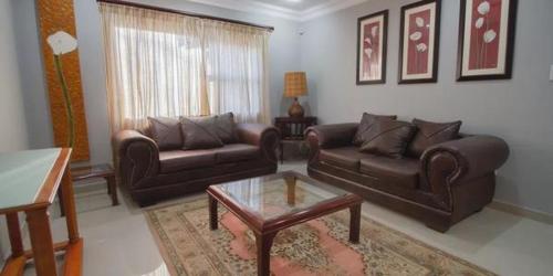 a living room with two couches and a coffee table at The Afropolitan in Johannesburg