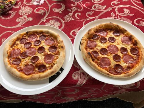 two pizzas sitting on white plates on a table at Hotel & Restaurant Garda in Darmstadt