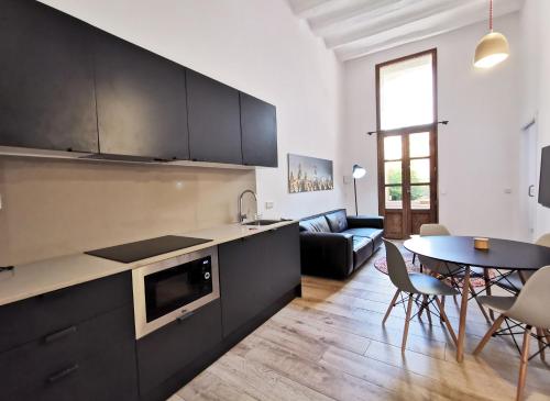 una cucina e un soggiorno con tavolo e sedie di ClassBedroom Port Ramblas a Barcellona