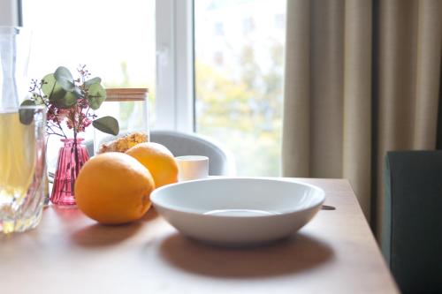 a table with a bowl and oranges on a table at Brera Leipzig in Leipzig