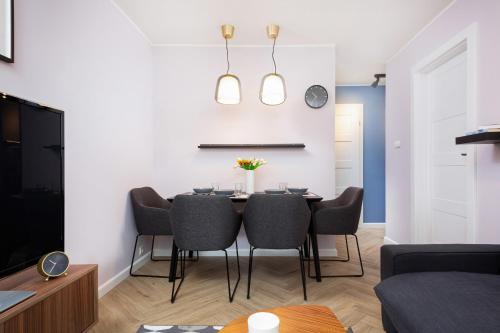 uma sala de jantar com mesa e cadeiras em Apartments Warsaw Nowowiejska by Renters em Varsóvia