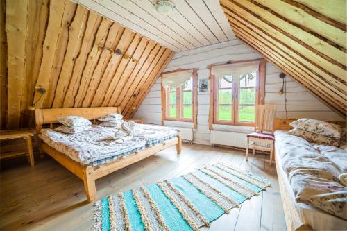 a bedroom with two beds in a log cabin at Arma Riding Farm And Holiday Home in Rutja