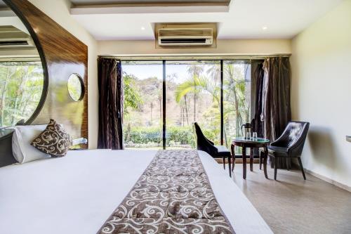 a bedroom with a large bed and a table with chairs at Hotel Royale Palace in Mount Ābu