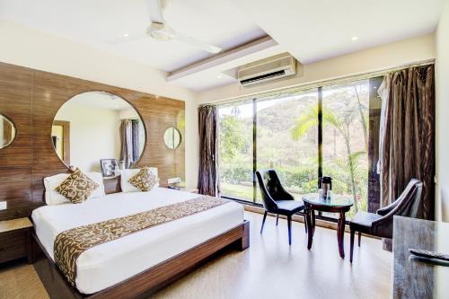 a hotel room with a bed and a large window at Hotel Royale Palace in Mount Ābu